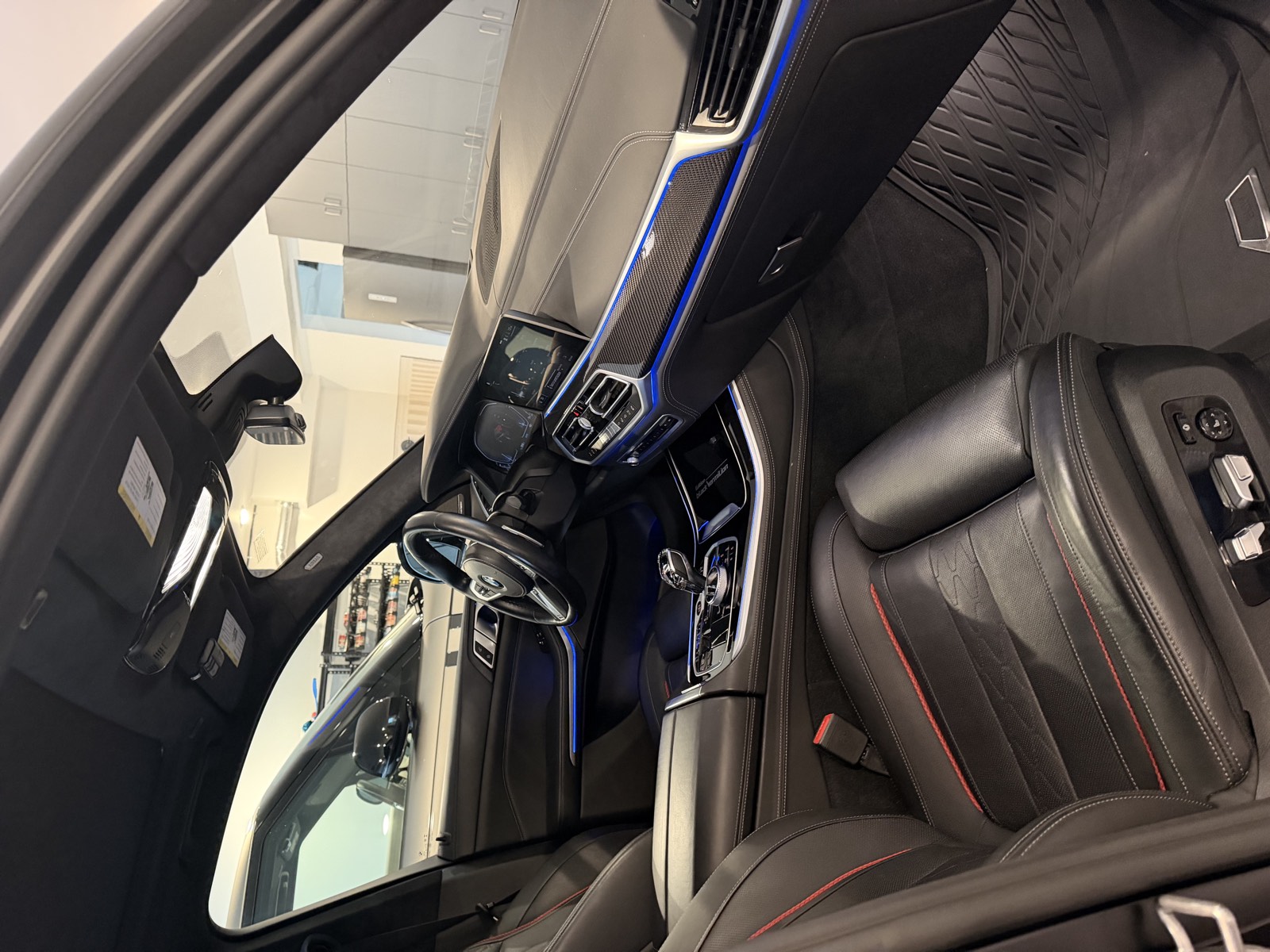 BMW interior with black leather seats and blue ambient light after a detail