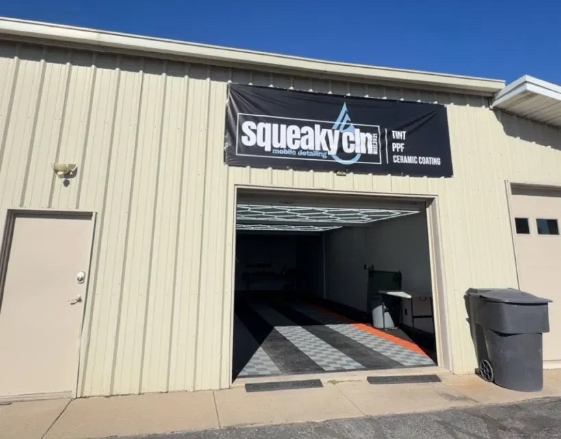 The Squeaky Clean shop in Morgan with its garage door open, showing a clean tiled floor and bright ceiling lights